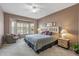 Main bedroom offers large windows, a ceiling fan, and neutral colors at 15116 W Carbine Way, Sun City West, AZ 85375