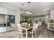 Bright dining room with backyard access, contemporary lighting, and an open view of the kitchen and living room at 1557 E Flower St, Gilbert, AZ 85298