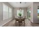 Bright dining room featuring wood-look flooring, contemporary lighting, and sliding glass doors for access to patio at 1557 E Flower St, Gilbert, AZ 85298