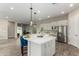 Spacious kitchen island with sleek countertops, pendant lighting, stainless appliances, and views to the living area at 1557 E Flower St, Gilbert, AZ 85298