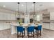 The large kitchen island features modern pendant lights, seating for three, and sleek countertops at 1557 E Flower St, Gilbert, AZ 85298