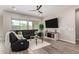 Relaxing living room featuring sleek, modern furniture, wood-look tile floors, and ample natural light at 1557 E Flower St, Gilbert, AZ 85298