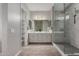 A main bathroom features double sinks, framed mirrors, and a large glass shower with marble style tiles at 1557 E Flower St, Gilbert, AZ 85298