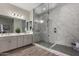 This main bathroom features double sinks, granite countertops, and a frameless walk-in shower at 1557 E Flower St, Gilbert, AZ 85298