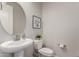 This modern powder room features a round mirror, sleek fixtures, and contemporary design at 1557 E Flower St, Gilbert, AZ 85298