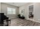 Room with wood-look tile floor, piano, and large window with plantation shutters at 1557 E Flower St, Gilbert, AZ 85298