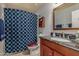 Well-lit bathroom features a granite countertop, wooden cabinets, and a shower with a patterned curtain at 15646 E Sunflower Dr, Fountain Hills, AZ 85268