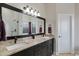 Bathroom with a large mirror, double sinks, granite countertops, and a shower behind glass blocks at 16102 E Glenview Dr, Fountain Hills, AZ 85268