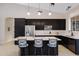 Modern kitchen featuring dark cabinets, stainless steel appliances, and a large island with seating at 16102 E Glenview Dr, Fountain Hills, AZ 85268