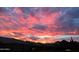 Striking sunset view with vibrant pink and orange clouds over the house rooftops at 16102 E Glenview Dr, Fountain Hills, AZ 85268