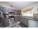 Modern kitchen with stainless steel appliances, gray cabinets, and tile backsplash at 16409 S 46Th St, Phoenix, AZ 85048