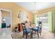 Bright dining area featuring a modern chandelier, glass table, and sliding glass door to the backyard at 1647 E Christina St, Casa Grande, AZ 85122