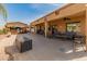 Spacious covered patio area with comfortable seating and an outdoor tiki bar at 17470 W Gelding Dr, Surprise, AZ 85388