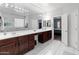 Spacious bathroom featuring double sinks with dark wood cabinets and elegant tile flooring at 17470 W Gelding Dr, Surprise, AZ 85388