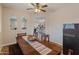 Dining room with a wooden table and chairs, decorative table runner, and a view into the kitchen and living room at 17470 W Gelding Dr, Surprise, AZ 85388