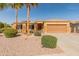 Charming home with desert landscaping, complemented by mature palm trees at 17470 W Gelding Dr, Surprise, AZ 85388