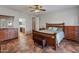 Spacious main bedroom with a wooden bed frame, dresser, and a view into the en-suite bathroom at 17470 W Gelding Dr, Surprise, AZ 85388