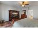 Main bedroom featuring a wooden bed frame, dresser with a mirror, and a large television entertainment center at 17470 W Gelding Dr, Surprise, AZ 85388