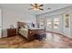 Spacious main bedroom with a ceiling fan and a bay window leading to the backyard at 17470 W Gelding Dr, Surprise, AZ 85388