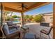 Cozy covered patio with comfortable seating and a view of the pool and backyard at 17470 W Gelding Dr, Surprise, AZ 85388