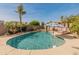 Sparkling pool features a sun umbrella, calming water feature, and is surrounded by lush landscaping at 17470 W Gelding Dr, Surprise, AZ 85388