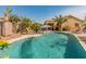 Backyard with a private pool, palm trees, lounge chairs, and desert landscaping at 17470 W Gelding Dr, Surprise, AZ 85388