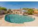 Beautiful backyard pool with a waterfall feature and lush tropical landscaping at 17470 W Gelding Dr, Surprise, AZ 85388