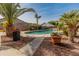 View of a backyard pool with a playful umbrella and lush landscaping in a backyard oasis at 17470 W Gelding Dr, Surprise, AZ 85388