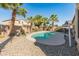 Lush backyard featuring a refreshing pool, palm trees, and desert landscaping at 18026 W Carmen Dr, Surprise, AZ 85388