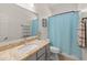 Bright bathroom featuring a granite countertop, vanity, and a shower with a blue curtain at 18026 W Carmen Dr, Surprise, AZ 85388