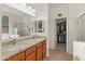 Bathroom featuring dual sinks, granite countertops, and a separate walk-in closet with ample storage at 18026 W Carmen Dr, Surprise, AZ 85388