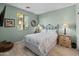 Cozy bedroom with wood-look tile flooring, a large window and stylish furnishings at 18026 W Carmen Dr, Surprise, AZ 85388