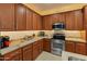 Well-lit kitchen featuring stainless steel appliances, granite countertops, and ample cabinet space at 18026 W Carmen Dr, Surprise, AZ 85388