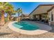 Backyard pool surrounded by palm trees and desert landscaping offers a private oasis at 18026 W Carmen Dr, Surprise, AZ 85388