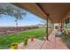 Inviting covered patio with comfortable seating, overlooking a lush green lawn and serene landscaping at 1844 E Cinnabar Ave, Phoenix, AZ 85020