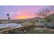 Sunset view of a backyard featuring a green lawn, a garden with string lights, and a mountain backdrop at 1844 E Cinnabar Ave, Phoenix, AZ 85020