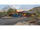 Charming single-story home with a gated driveway and a 2-car garage surrounded by desert landscaping at dusk at 1844 E Cinnabar Ave, Phoenix, AZ 85020