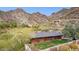 Rear view of hillside home with covered patio overlooking the well maintained backyard and scenic mountains at 1844 E Cinnabar Ave, Phoenix, AZ 85020