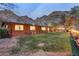 Exterior view of the brick ranch style home with large grassy yard, patio and mountain views at 1844 E Cinnabar Ave, Phoenix, AZ 85020