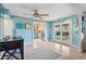 Bright living area with a ceiling fan, blue walls, tile floors, and access to the backyard through French doors at 1844 E Cinnabar Ave, Phoenix, AZ 85020