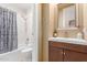 Bathroom featuring a tub and shower combination with tile surround and a single vanity with dark cabinets at 18468 N 63Rd Dr, Glendale, AZ 85308