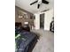 This bedroom has neutral tones, a dark ceiling fan, and an open door to the hallway at 18468 N 63Rd Dr, Glendale, AZ 85308