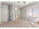 This bedroom features neutral tones, a large window, a ceiling fan, and a closet with mirrored doors at 18468 N 63Rd Dr, Glendale, AZ 85308