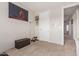 Hallway with a painting on the wall, a door, a dark ottoman, and carpet flooring at 18468 N 63Rd Dr, Glendale, AZ 85308