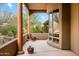 Inviting back porch with sturdy support beams overlooking a desert landscape with lush greenery and cacti at 18944 E Amethyst Dr, Rio Verde, AZ 85263