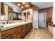 Bathroom with double sinks, wood cabinets, tile floors, and white walls at 18944 E Amethyst Dr, Rio Verde, AZ 85263