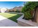 Backyard with artificial turf and green hedges around the perimeter for privacy at 19975 W Glenrosa Ave, Litchfield Park, AZ 85340