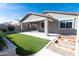 Backyard featuring manicured artificial turf, covered patio, and garden beds, ready for relaxing at 19975 W Glenrosa Ave, Litchfield Park, AZ 85340