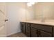 Bathroom with modern dark-wood cabinets, sink, large mirror, and wood-look flooring at 19975 W Glenrosa Ave, Litchfield Park, AZ 85340