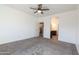 Carpeted bedroom with white walls, fan and view into the ensuite bath and kitchen at 19975 W Glenrosa Ave, Litchfield Park, AZ 85340